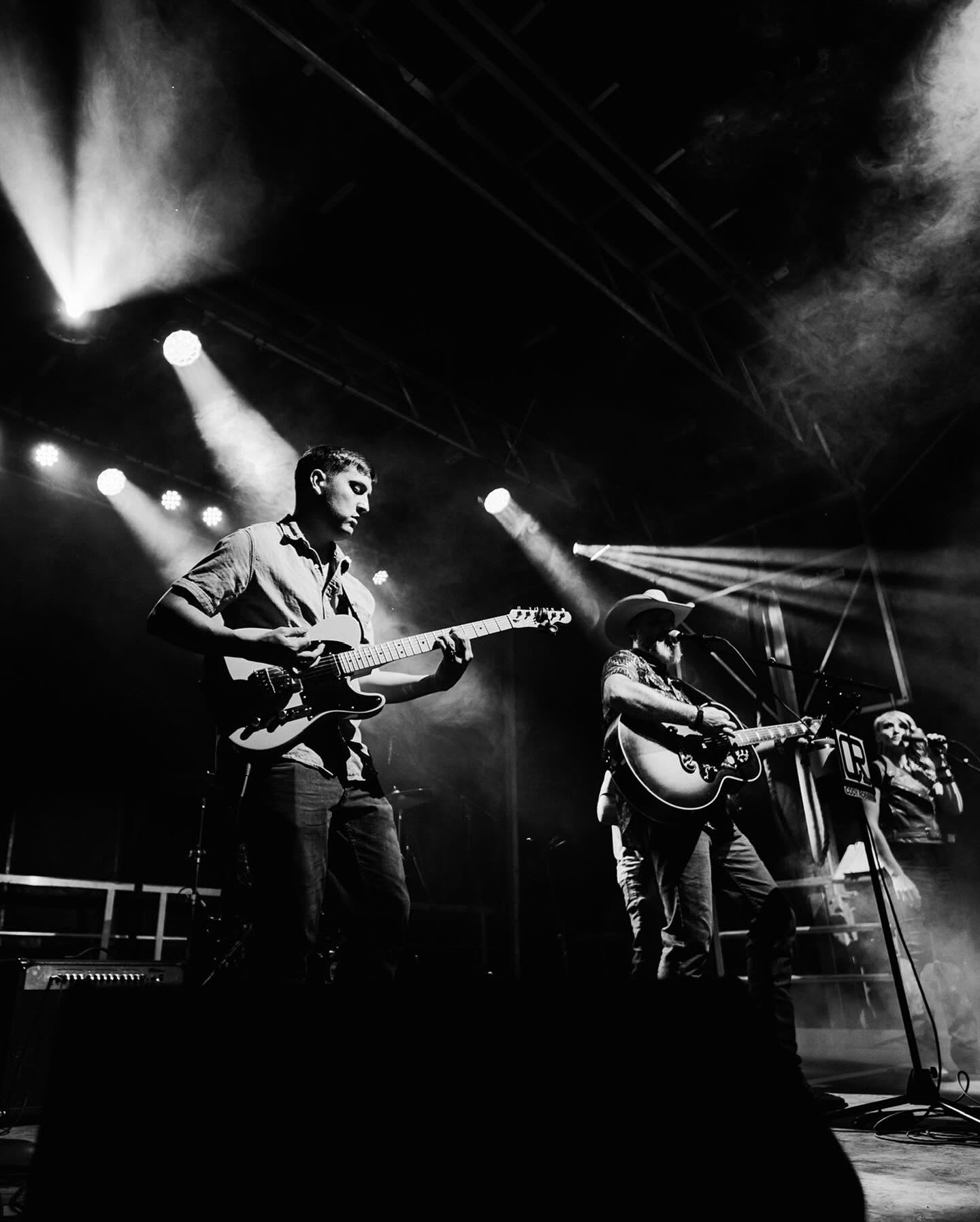 Band performing on stage under spotlights